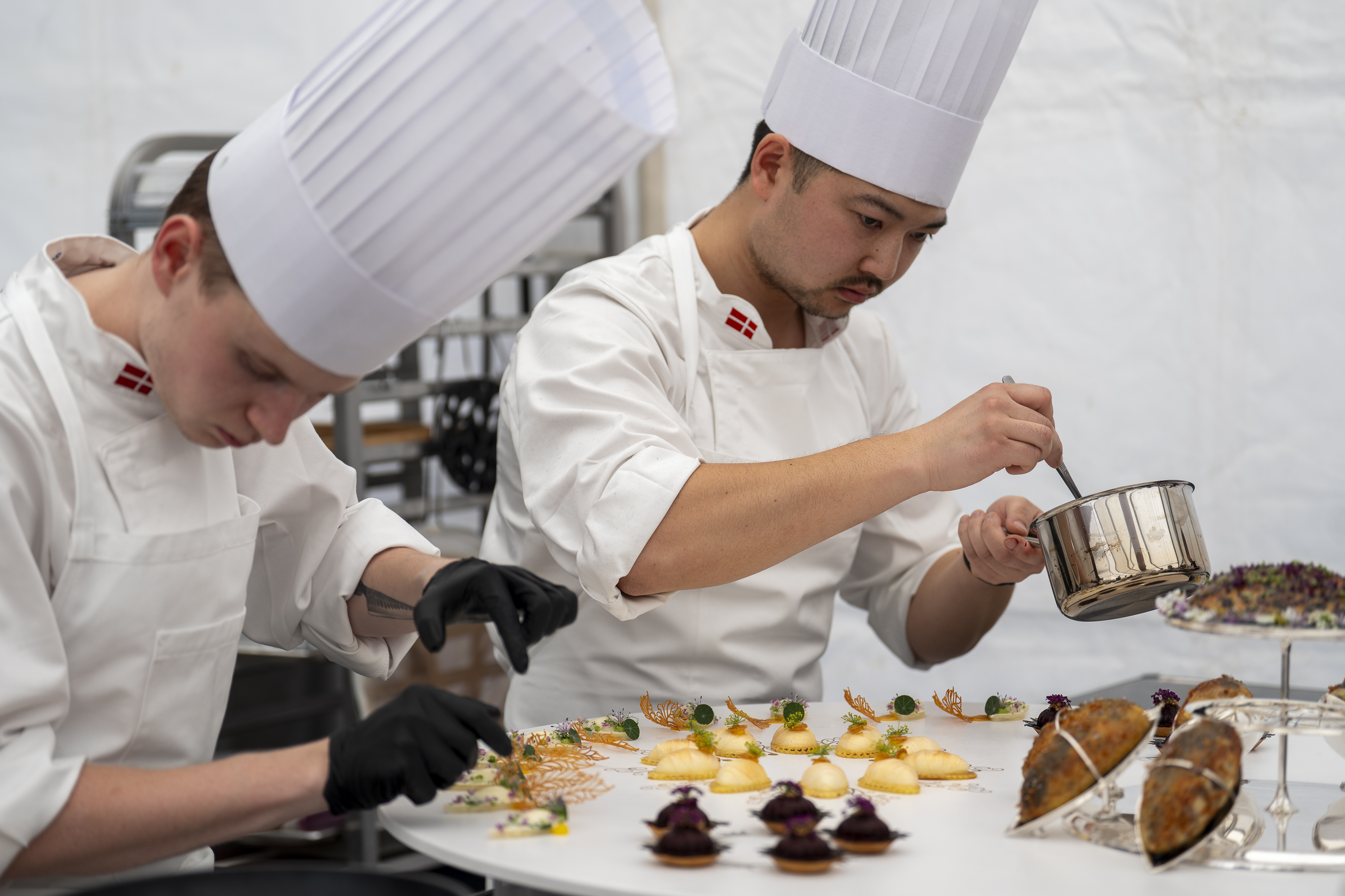 Commis Gustav Spurré (tv.) og kok Christian Wellendorf i fuld gang med de sidste detaljer inden servering i fredags. Foto: Mathilde Thykier, Bocuse d'Or Danmark